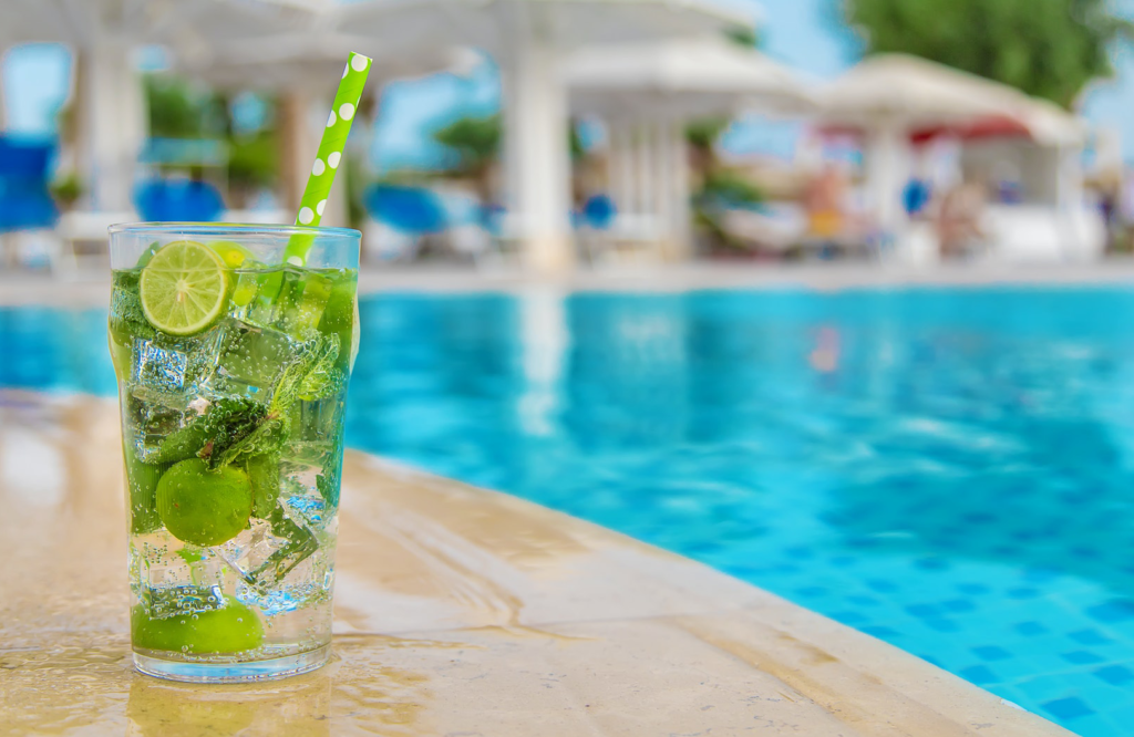 ClubU, Tu Club Exclusivo de Ocio y Deporte Cálig. Mojito en el borde de una piscina con agua cristalina.